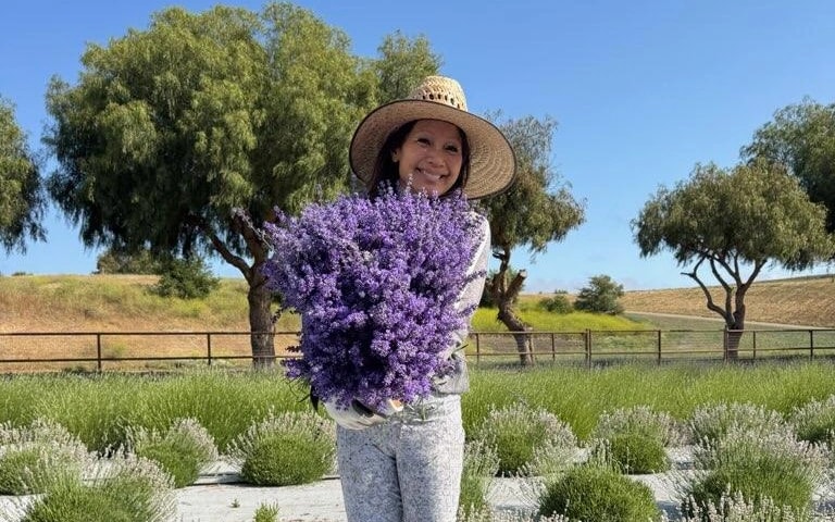 Lisa holding a large bunch of lavender in the field